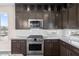 Kitchen with stainless steel appliances, granite countertops, and dark cabinets at 8116 Haywood Estate Ave, Las Vegas, NV 89113