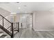 Open living area with gray flooring, a staircase, and multiple doorways at 8116 Haywood Estate Ave, Las Vegas, NV 89113