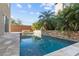 Sparkling pool surrounded by travertine pavers and lush tropical plants for a serene retreat at 8116 Haywood Estate Ave, Las Vegas, NV 89113