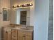 Bright bathroom featuring a double sink vanity, a large mirror with vanity lighting and a view into a closet at 8244 Sickle Ln, Las Vegas, NV 89128
