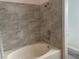 Clean bathroom featuring tiled walls, a bathtub, and modern fixtures at 8244 Sickle Ln, Las Vegas, NV 89128