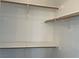 Walk-in closet with wooden shelving and rods, providing ample storage space at 8244 Sickle Ln, Las Vegas, NV 89128