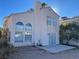 Exterior view of the home showcasing the stucco, arched windows, patio and tile roof details at 8244 Sickle Ln, Las Vegas, NV 89128