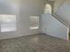 Spacious, naturally lit living room with tile flooring and a staircase leading upstairs at 8244 Sickle Ln, Las Vegas, NV 89128