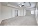 Spacious bedroom featuring neutral carpet, tray ceiling with fan and walk-in closet at 9629 Grouse Grove Ave, Las Vegas, NV 89148