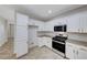 Bright kitchen boasts granite countertops, stainless steel appliances, and white cabinets with gold hardware at 9629 Grouse Grove Ave, Las Vegas, NV 89148