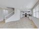Open-concept floorplan features white staircase, tile floor and white kitchen in background at 9629 Grouse Grove Ave, Las Vegas, NV 89148