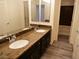 Bathroom features dual sinks, dark cabinets, granite counters, and vanity mirrors at 9739 Fox Estate St, Las Vegas, NV 89141