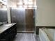 Bathroom features a glass enclosed shower, garden tub and granite counters at 9739 Fox Estate St, Las Vegas, NV 89141