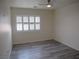 Bedroom with modern gray flooring, white walls, ceiling fan and shuttered window at 9739 Fox Estate St, Las Vegas, NV 89141