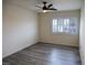 Bedroom with modern gray flooring, ceiling fan and shuttered window at 9739 Fox Estate St, Las Vegas, NV 89141