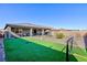 Inviting backyard featuring a synthetic grass lawn, desert landscaping, and a covered patio with outdoor seating at 10095 Ferton Lake Ave, Las Vegas, NV 89178