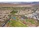 Expansive aerial view of a Primary-planned community with parks, tennis courts, and lush landscaping against a desert backdrop at 11283 Gravitation Dr, Las Vegas, NV 89135