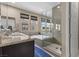 Bathroom featuring double sinks, a soaking tub, and a glass-enclosed shower at 11283 Gravitation Dr, Las Vegas, NV 89135