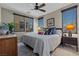 Comfortable bedroom featuring a ceiling fan, cozy rug, and natural light from windows at 11283 Gravitation Dr, Las Vegas, NV 89135
