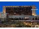 A breathtaking shot of the illuminated exterior of the Red Rock Casino Resort and Spa at dusk at 11283 Gravitation Dr, Las Vegas, NV 89135