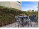 Cozy outdoor patio featuring a dining set and privacy wall covered in lush greenery for tranquil outdoor dining at 11283 Gravitation Dr, Las Vegas, NV 89135