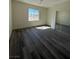 A cozy bedroom featuring hardwood floors, a window, and a sliding door mirrored closet at 1351 Huckleberry St, Pahrump, NV 89048