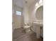 View of the bathroom with a toilet, sink, mirror, and a small window at 150 Short Ruff Way, Las Vegas, NV 89148