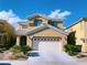 Charming two-story home with a well-manicured lawn and a two-car garage under a sunny sky at 150 Short Ruff Way, Las Vegas, NV 89148