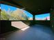 Covered patio with tiled flooring and views of the surrounding lush greenery and blue skies at 150 Short Ruff Way, Las Vegas, NV 89148