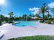 Large community pool featuring clear, blue water, sun umbrellas, and lush palm trees at 150 Short Ruff Way, Las Vegas, NV 89148