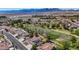 Expansive aerial view of a residential area featuring houses, green spaces, and a stunning mountain backdrop at 1598 Bermuda Dunes Dr, Boulder City, NV 89005