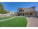 Expansive backyard with a covered patio, lush green lawn, and desert landscaping, perfect for outdoor living at 1598 Bermuda Dunes Dr, Boulder City, NV 89005
