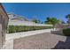 The backyard has a gravel area, and a wall of shrubs and trees at 1598 Bermuda Dunes Dr, Boulder City, NV 89005