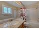 Bright bathroom with granite counters, tile floor, and shower over tub with curtains at 1598 Bermuda Dunes Dr, Boulder City, NV 89005