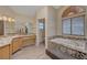 Primary bathroom featuring dual sinks, vanity, wood look floors, tub, and shower at 1598 Bermuda Dunes Dr, Boulder City, NV 89005