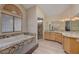 Primary bathroom featuring dual sinks, vanity, wood look floors, tub, and shower at 1598 Bermuda Dunes Dr, Boulder City, NV 89005