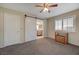 Comfortable bedroom featuring a barn door, ceiling fan and shuttered windows at 1598 Bermuda Dunes Dr, Boulder City, NV 89005