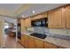 Bright kitchen with granite counters, wood cabinets, and black appliances at 1598 Bermuda Dunes Dr, Boulder City, NV 89005