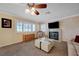 Cozy living room with a fireplace, ceiling fan, and plantation shutters at 1598 Bermuda Dunes Dr, Boulder City, NV 89005