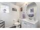 A clean bathroom with an oval mirror, a white vanity and toilet at 1893 Donnington Ct, Las Vegas, NV 89123