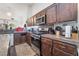 A functional kitchen features granite countertops, dark cabinets and stainless steel appliances at 1893 Donnington Ct, Las Vegas, NV 89123