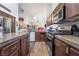 Well-lit kitchen with dark cabinets, stainless steel appliances, and granite countertops at 1893 Donnington Ct, Las Vegas, NV 89123