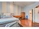 A bright bedroom features stripped accent wall, light hardwood floors, and decorative furnishings in a clean design at 2024 Riva Del Garda Pl, Las Vegas, NV 89134