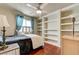 Bedroom with window light, built-in bookcase, hardwood floors, ceiling fan, and neutral wall color at 2024 Riva Del Garda Pl, Las Vegas, NV 89134