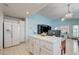 Bright kitchen featuring a refrigerator, white cabinets and seamless transition into an adjacent living space at 2024 Riva Del Garda Pl, Las Vegas, NV 89134
