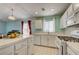 Bright eat-in kitchen featuring tile countertops, white cabinets, and modern appliances at 2024 Riva Del Garda Pl, Las Vegas, NV 89134