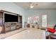 Open-concept living room with entertainment center, ceiling fan and natural light at 2024 Riva Del Garda Pl, Las Vegas, NV 89134