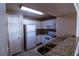 The kitchen features white appliances, modern cabinets, and granite countertops at 2300 E Silverado Ranch Blvd # 1180, Las Vegas, NV 89183