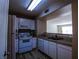 Bright kitchen features white appliances, wood floor, and granite countertops at 2300 E Silverado Ranch Blvd # 1180, Las Vegas, NV 89183