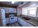 Well-lit kitchen features white appliances, ample cabinetry, and a breakfast bar overlooking the living area at 2300 E Silverado Ranch Blvd # 1180, Las Vegas, NV 89183