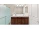 Bathroom with a double sink vanity with dark wood cabinets, shower with glass doors, and neutral paint at 2409 Bellinzona Pl, Henderson, NV 89044