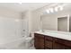 Clean bathroom with a tub-shower combo, white tile surround, dark vanity, and modern lighting at 2409 Bellinzona Pl, Henderson, NV 89044