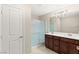 Bathroom featuring a double sink vanity with a modern light fixture and a shower with glass doors at 2409 Bellinzona Pl, Henderson, NV 89044