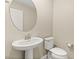 Powder room features a pedestal sink, oval mirror and white toilet at 2409 Bellinzona Pl, Henderson, NV 89044